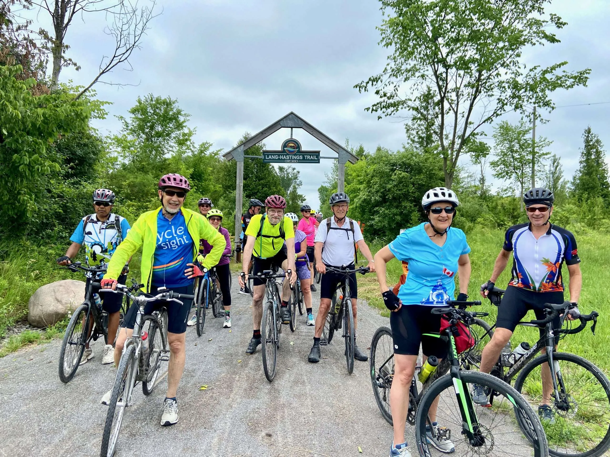 Group of cyclists riding together on a sunny road in Nelson